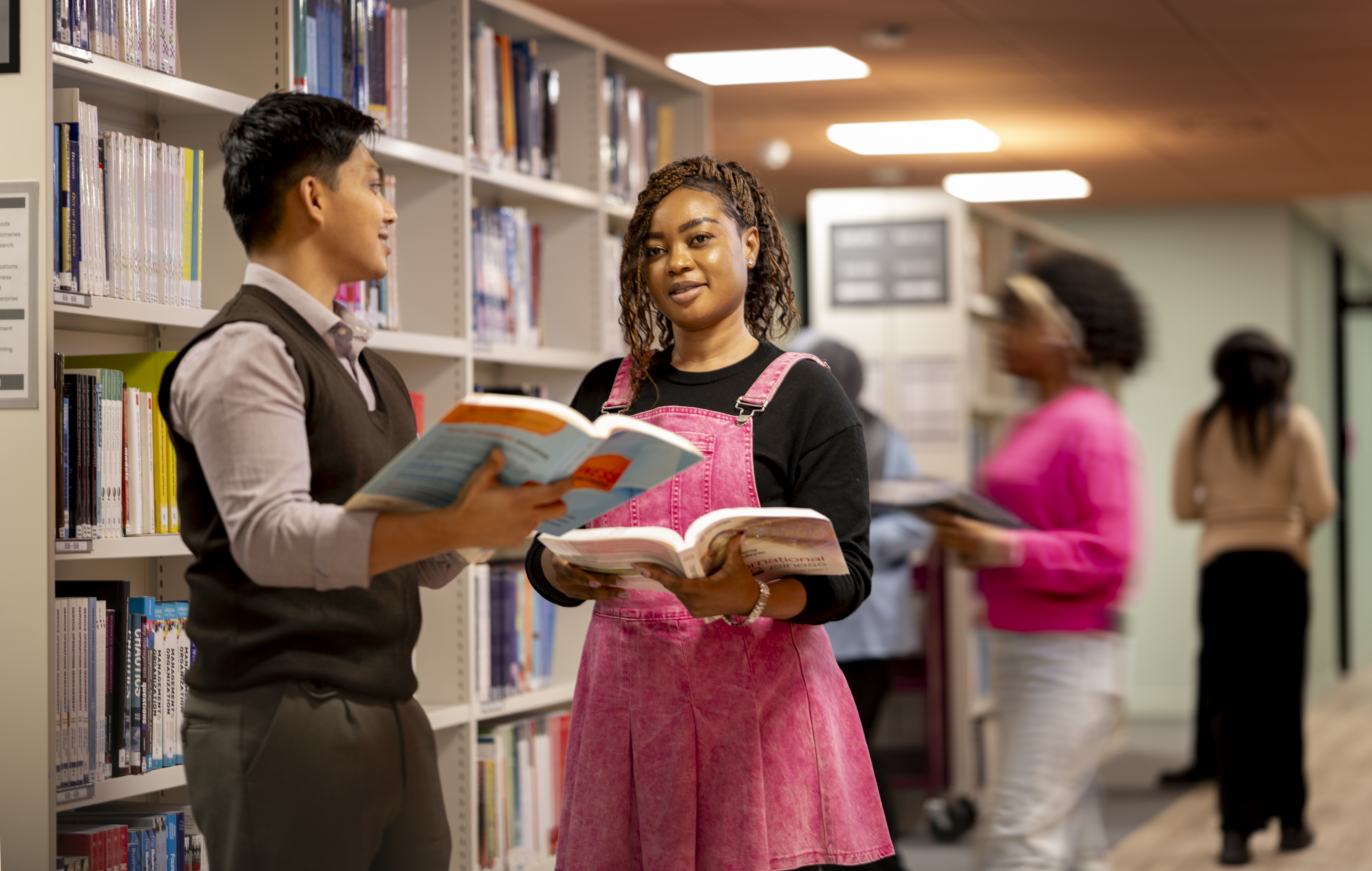 students amongst bookshelves